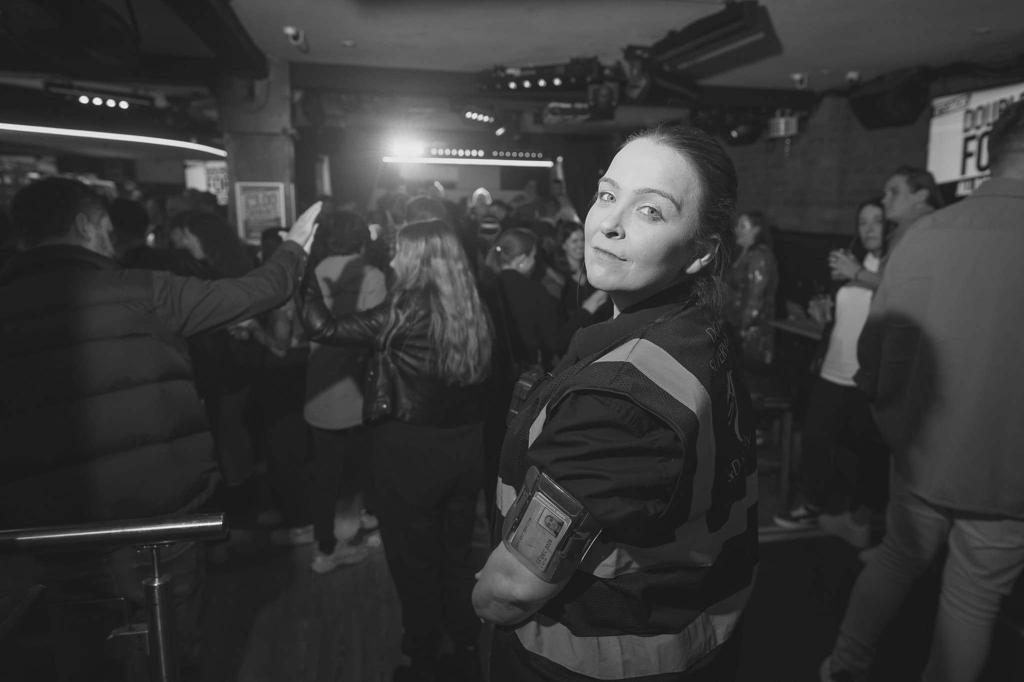 A C&D Security door supervisor on shift inside a busy late-night venue
